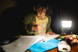 Navajo Girl doing homework by lantern skip the grid