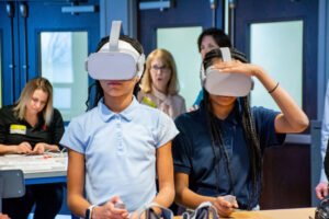Verizon STEM lab kids in blue shirts with VR headset