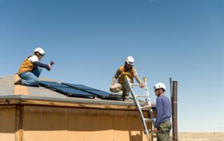 Three participants in Heart of America's Skip the Grid initiative are installing solar panels on the roof of a Navajo Nation home.